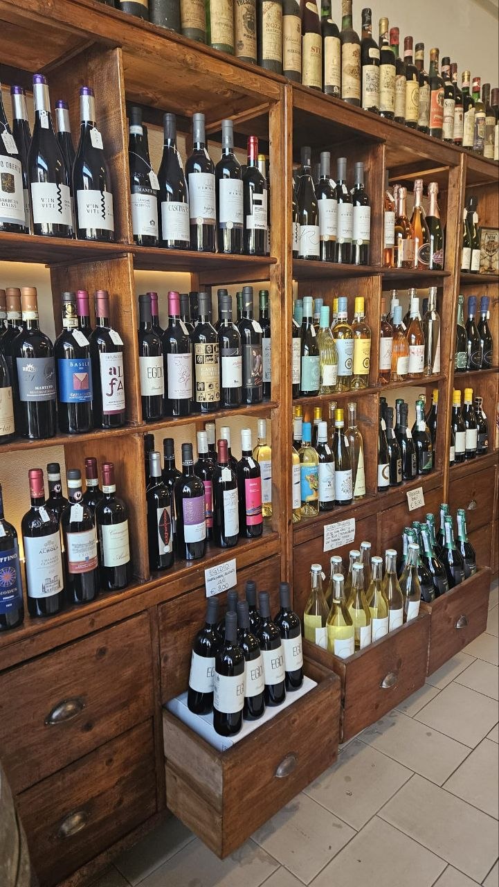 Scaffali in legno con bottiglie di vino selezionate da VINITO